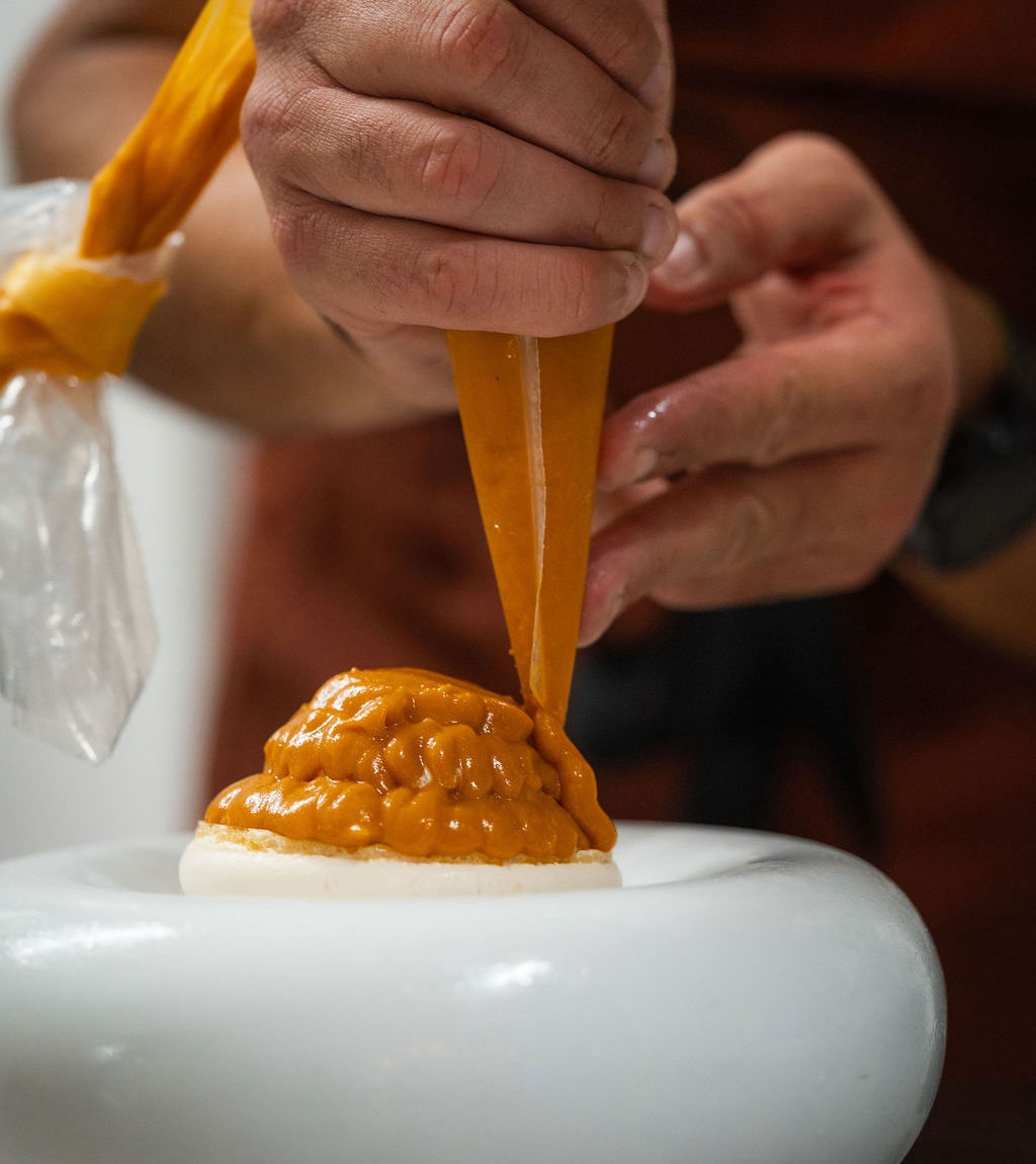Dressage à l'assiette au Restaurant du Lavoir : une crème est déposée à la poche sur un fond croustillant.